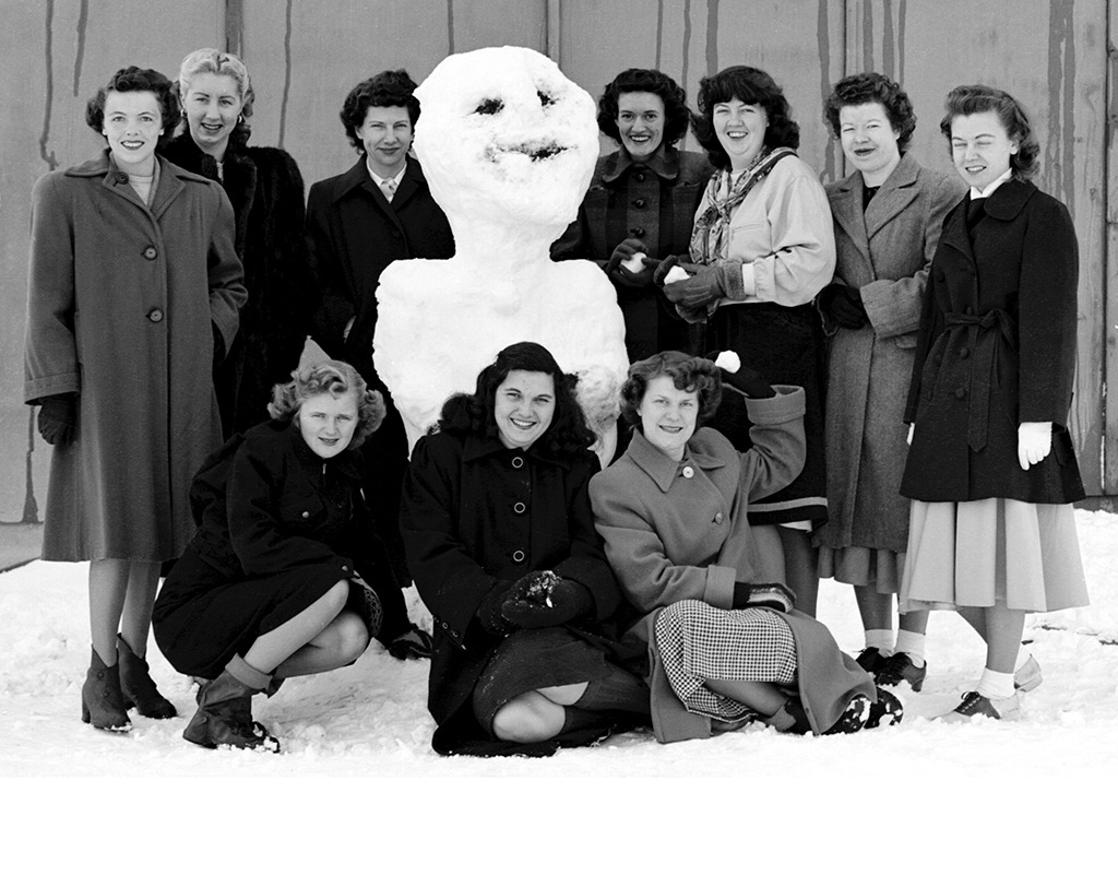 Photo of ten women who worked as human computers for NASA outside with a snowman