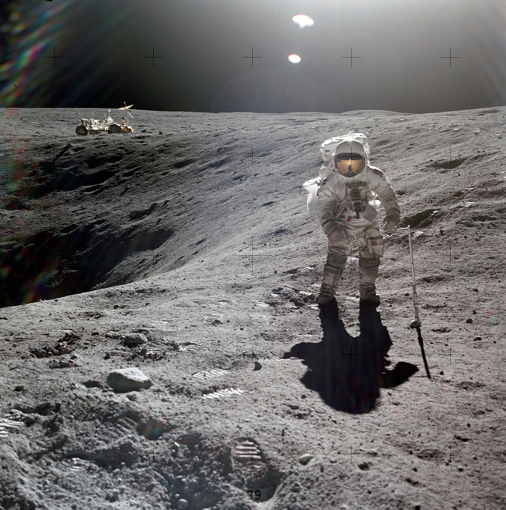 Charles Duke in an astronaut suit standing on the moon