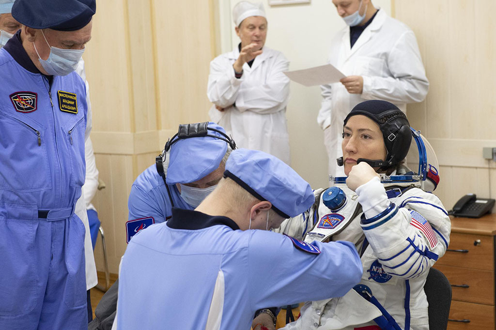 Christina Koch and several scientists prepare her for launch