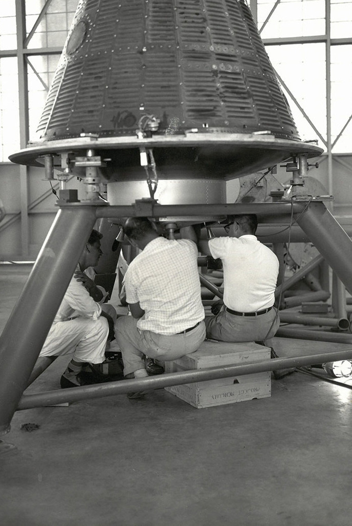 technicians install and check rockets on a spacecraft