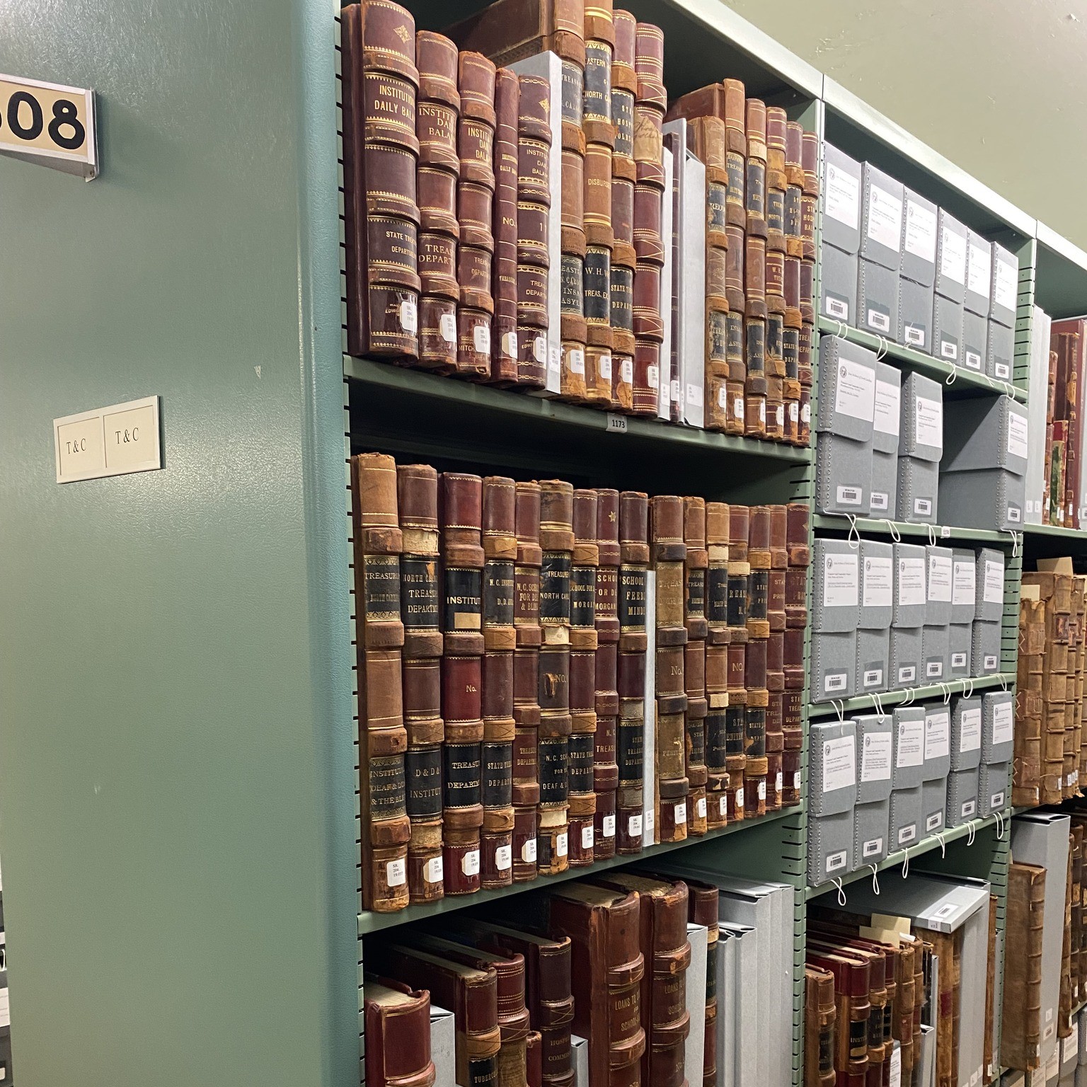 metal shelves full of bound archival documents and archival boxes at the State of NC Archives