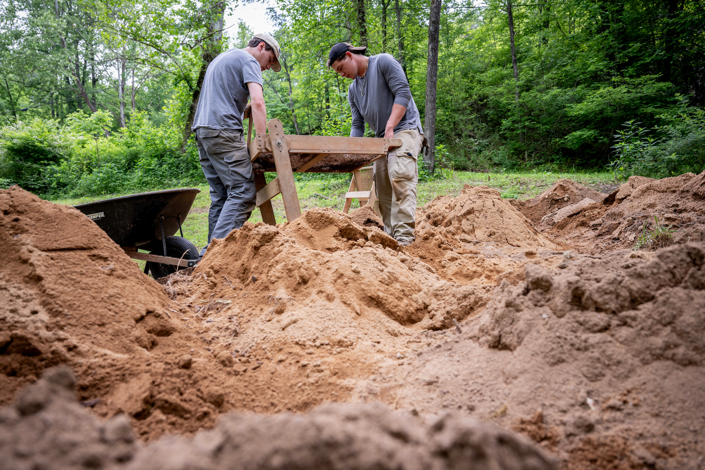 Two undergraduate students from Western Carolina University sift through soil during excavations at the Cowee Tunnel Prison Labor Camp, 2024