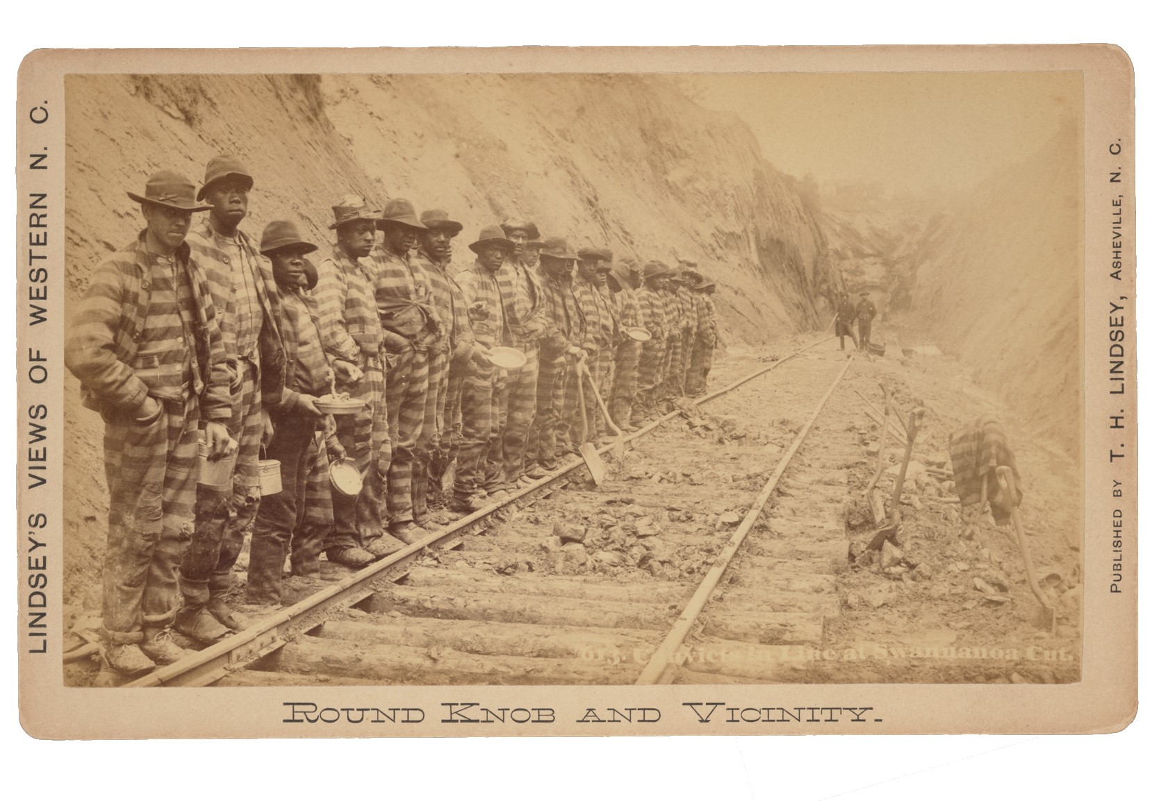 A postcard with a photograph of incarcerated men and boys standing along the Western North Carolina Railroad