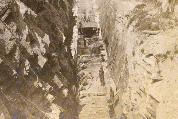 Incarcerated workers and guards on the Western North Carolina Railroad in a cut on a flat car, circa 1878-79